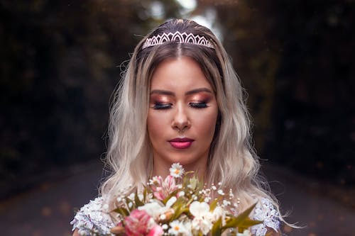 Photo of A Bride Holding a Bouquet of Flowers Stock Photo